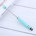 Multifunctional Tiffany blue touchscreen stylus pen on a minimalist white wood background - Candy Light Blue
