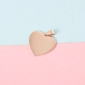 Detailed view of 25mm rose gold heart pendant with polished mirror finish on pink blue background - Rose Gold