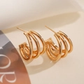 Detail van 18K vergulde geometrische oorringen met een modern gelaagd ontwerp met ringen - 4-laags Ringontwerp / Goud (45517)