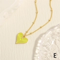Detalle macro de colgante de corazón con esmalte amarillo y cadena de bolas doradas - Amarillo Brillante
