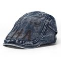 Close-up of vintage washed denim newsboy cap with brown graffiti print and white stitching - Style D-Washed Dark Blue (HA)