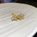 Nahaufnahme eines glitzernden gelben Zirkonia-Schmetterlingsrings auf weißer Keramik - Schmetterling Offener Ring / Gelb