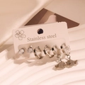 Close-up of stainless steel earring set featuring zircon studs and fish charms on a card - Small Fish Rhinestone Set