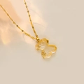 Macro view of golden water wave chain and matte resin bear pendant with star zircon inlay - White Lip Chain