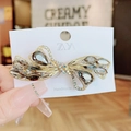 Elegant gold butterfly hair clip with deep grey rhinestones on a display card - Butterfly Knot Grey Spring Clip