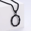 Dettaglio macro di una collana in acciaio inossidabile nero opaco con pendente ad anello - Lettera O (Nero Con Catena)