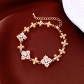 Détail du bracelet fleuri plaqué or 18K avec zircone sur fond en velours rouge - Or Blanc Zircone