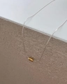 Close-up of a minimalist silver chain featuring a polished gold oval coffee bean pendant - Silver Millet Bead Necklace