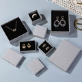 Detailed overhead view of luxury gray textured paper jewelry boxes for rings and necklaces - Koala Grey