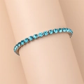 Detailed close-up of light blue zircon tennis bracelet on wrist with silver metal base - 18cm / Sapphire Blue