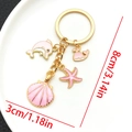 Llavero dorado con colgantes de esmalte rosa de delfín y estrella de mar - Delfín Concha Rosa (LS551)