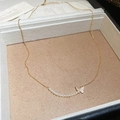 Dettaglio di una collana a farfalla placcata oro 18k con zirconi e perle bianche - Collana Oro