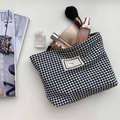 Detailansicht der Hahnentritt-Kosmetiktasche mit Make-up und Pinseln darin - Schwarz und Weiß Hahnentritt