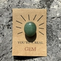 Gros plan d'une pierre gemme verte sur carte en kraft avec texte You're a Real Gem - Aventurine Verte