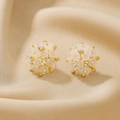 Close-up of 18K gold flower cluster earrings with white petals and zircon pearls on silk - Alloy 3D Flower Stud Earrings