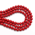 Detailed close-up of glossy red round faux pearl beads for DIY jewelry making - Red