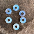 Translucent white opal abacus spacer beads for DIY jewelry on a textured rock base - Opal