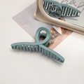 Detail of large matte grey-blue shark hair claw clip on desk with vintage mirror - Cross / Milky Blue