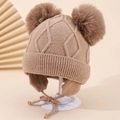 Detailaufnahme der Strickmütze mit Rautenmuster, Ohrenklappen und Kunstfell-Pompons - 1-3 Jahre / Braun