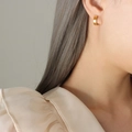 Orecchini a cerchio a clip in acciaio inossidabile placcato oro 18k su una modella donna - Clip per orecchie oro