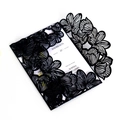 Detail of laser cut black wedding invitation sleeve with intricate hollow pattern - Black