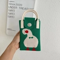 Detail of green knitted phone bag featuring a white duck pattern and a silver metal clasp - Green Tilting Head Duck