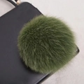 Gros plan d'un pompon en fourrure naturelle vert olive montrant sa texture douce - Style Bouton Pression 14CM / Vert Militaire