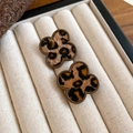 Detailed close-up of clover-shaped leopard print earrings on a beige velvet jewelry box - Brown Clover Style (15#)
