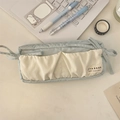Dettaglio dell'astuccio in tela azzurra con tasche crema e nastri a fiocco decorativi - Blu Bianco