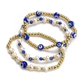Detailed view of three-piece set featuring golden beads and blue evil eye charms - Layered Blue Eye Pearl Gold Bead Style (BE843MI04)