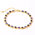 Detail van gouden armband met blauwe boze oog hartjes en een karabijnsluiting - 18K goud / Blauw