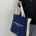 London Review of Books navy and white canvas tote bag shown held by a model - Blue