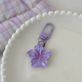 Detail eines lila Kirschblüten-Schlüsselanhängers auf einem Dekoteller - Lila