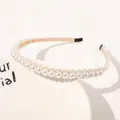 Detailed view of triple-row white pearl headband with gold ribbon and black rubber tips - Full Flowers Large Pearls