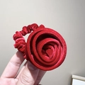 Gros plan détaillé d'un grand chouchou rose en velours rouge avec une texture de tissu doux - Chouchou Fleur Rose en Velours Bordeaux