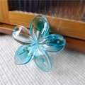 Dettaglio ravvicinato della molletta per capelli a forma di fiore blu trasparente con molla in metallo - Blu-Trasparente