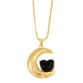 Macro shot of gold moon pendant featuring a black heart stone and white cubic zirconia - Black