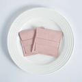 Detail of pink microfiber suede jewelry pouches with flap closure on a white plate - Pink