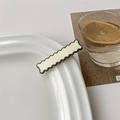 Detail einer cremefarbenen Haarklammer mit schwarzem Wellenrand auf weißem Porzellanteller - 4# Weiße Welle mit Schwarzem Rand