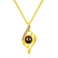 Macro shot of gold projection necklace featuring flame pendant with center stone and cubic zirconia - Abstract Curve Gold