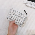Close-up of small tweed coin purse with zipper and simple wish label in hand - Tweed White