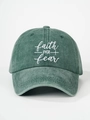Detailed close-up of FAITH OVER fear embroidery on a dark green washed cotton baseball cap - Dark Green