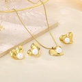 Close-up of golden heart-shaped jewelry set with white pearls on a stone tray - Heart Shaped Pearl Jewelry Collection (KS220719-LX)
