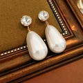 Macro detail of gold vintage drop earrings with sparkling crystals and white teardrop pearls - Silver Needle Waterdrop Pearl Style / White