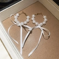 Detailed view of elegant white pearl hoop earrings with delicate satin ribbon bows - Silver Earring Post-White