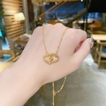 Elegante collana dorata con due cuori intrecciati sulla mano, stile minimalista - Stile Ciondolo a Doppio Cuore Interbloccato (X033) / Oro