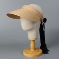 Detail of raffia straw sun visor featuring a black decorative ribbon bow and open top design - M (56-58cm) / Beige + Black Ribbon