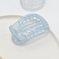 Close-up of light blue acetate hair claw with marble texture on white ceramic plate - 12# Blue Mermaid PVC Claw