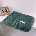 Detail of green linen scarf with fringe edges and Autumn On Line label on white surface - 180*90CM / Dark Green Patchwork