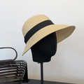 Straw sun hat with wide brim, black ribbon bow and natural woven texture on model - 55-60cm (Adjustable) / Beige